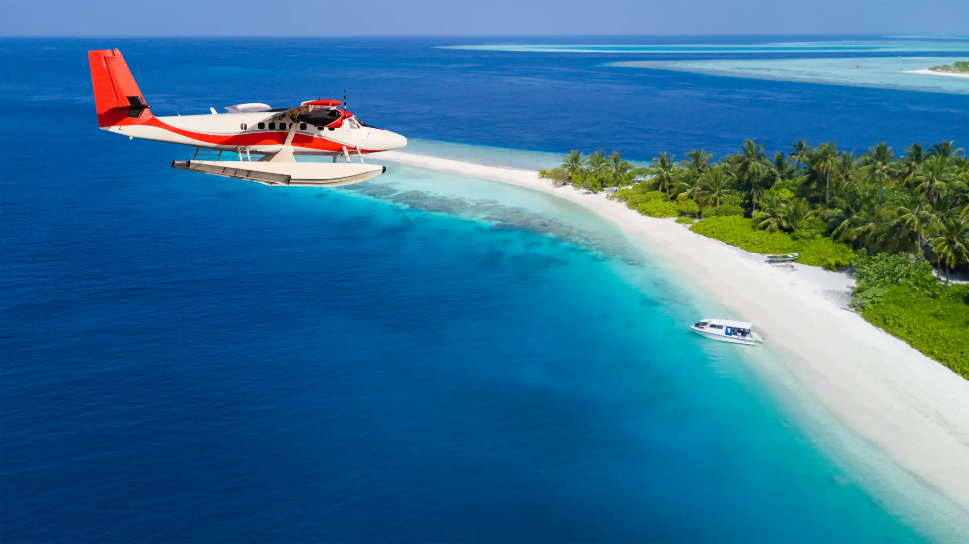 airplane flying by white sand beach